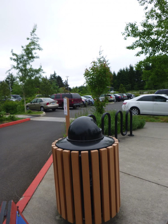 Parking lot has several accessible spaces – sidewalk has a bike rack, trashcan and interpretive signage